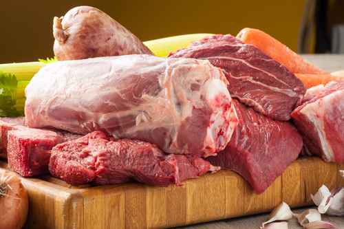 Tagli di carne bovina e suina cruda appoggiati sul tagliere
